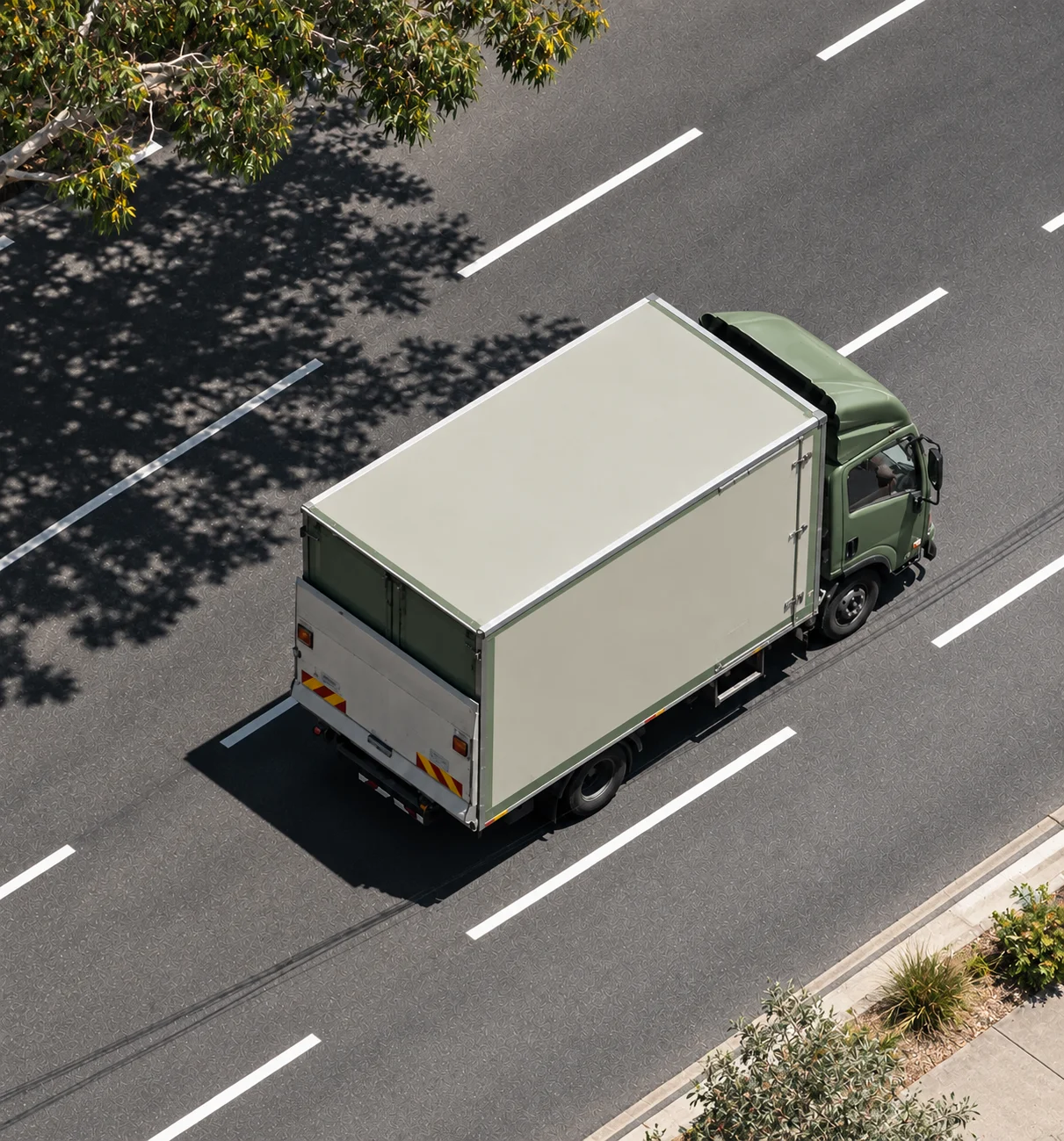 Sage and white freight truck photographed from above